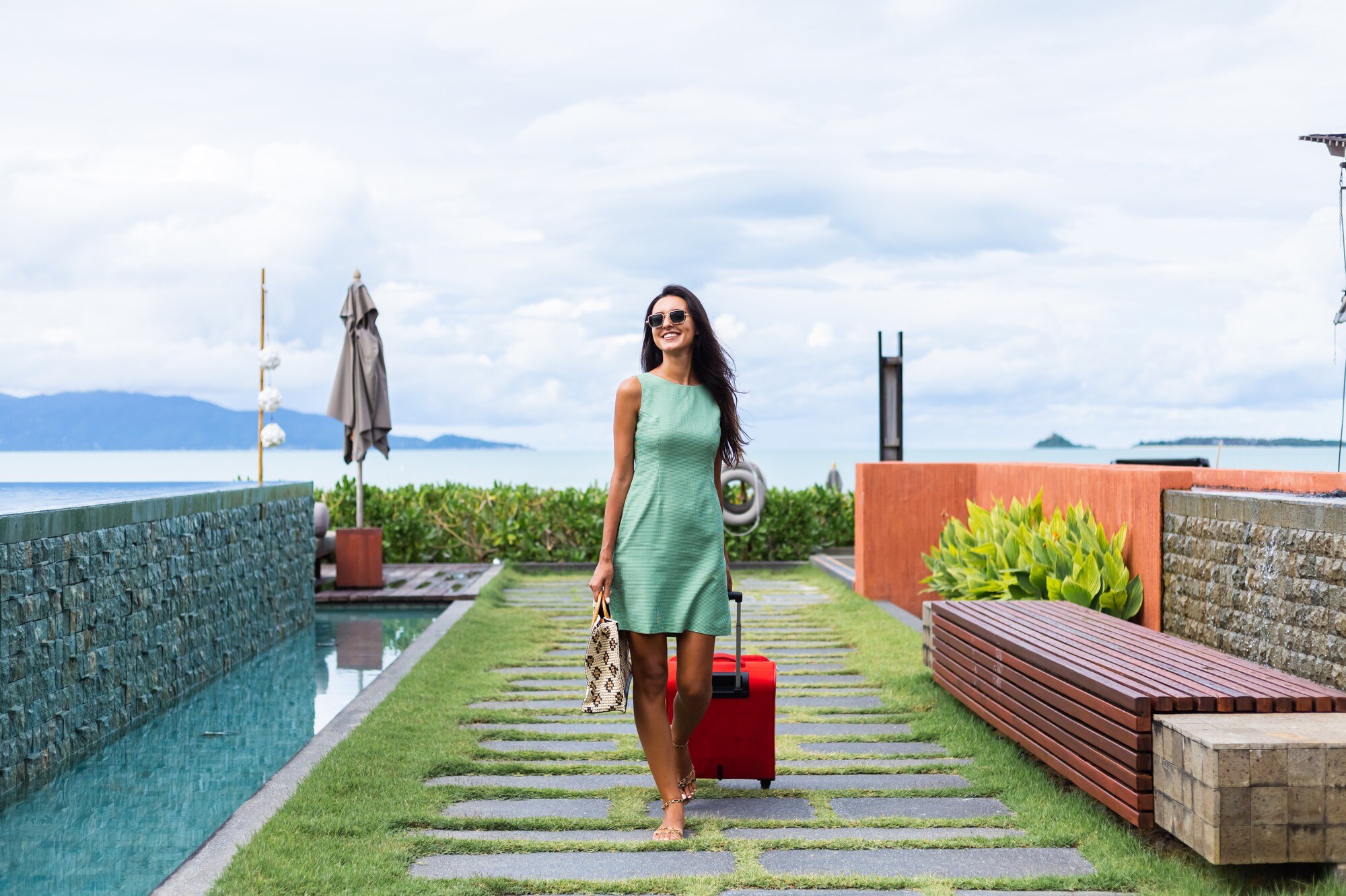 happy-caucasian-pretty-long-hair-elegant-tourist-woman-dress-with-red-suitcase-outside-hotel_343596-3664